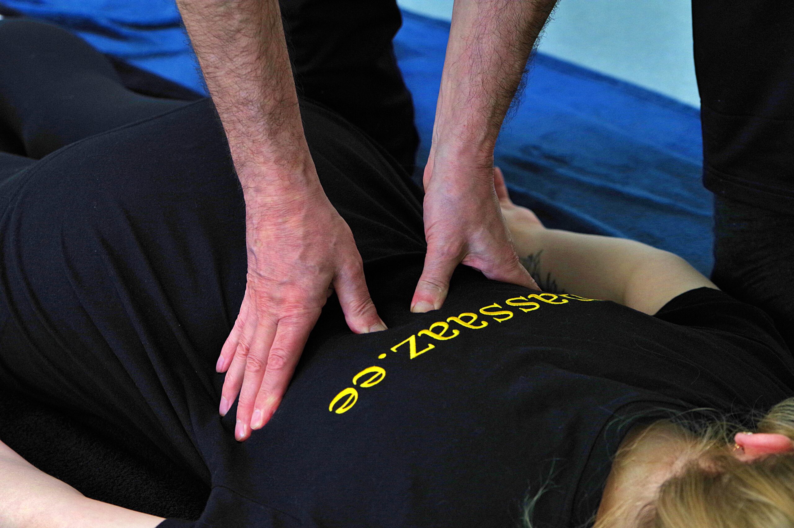 Shiatsu ülakeha massaaži koolitusel juhendaja töötamas kaela, õlgade ja käte piirkonna survepunktidega